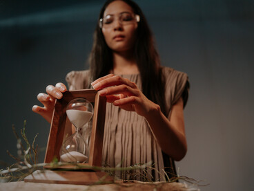 A woman holding an hourglass, capturing the essence of arresting time through science, habit, and intention