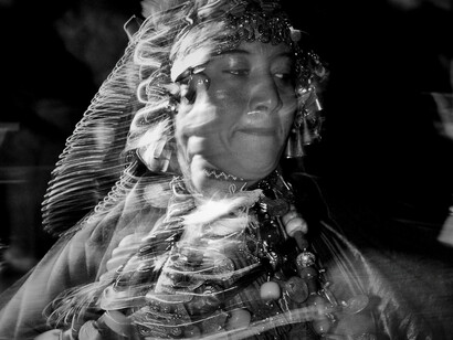 A woman decked in traditional jewels captured as she twirls harmoniously to the rhythm