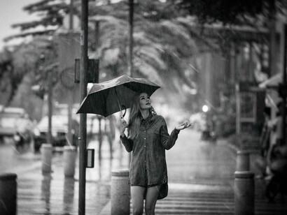 Woman walking alone on the street with an umbrella