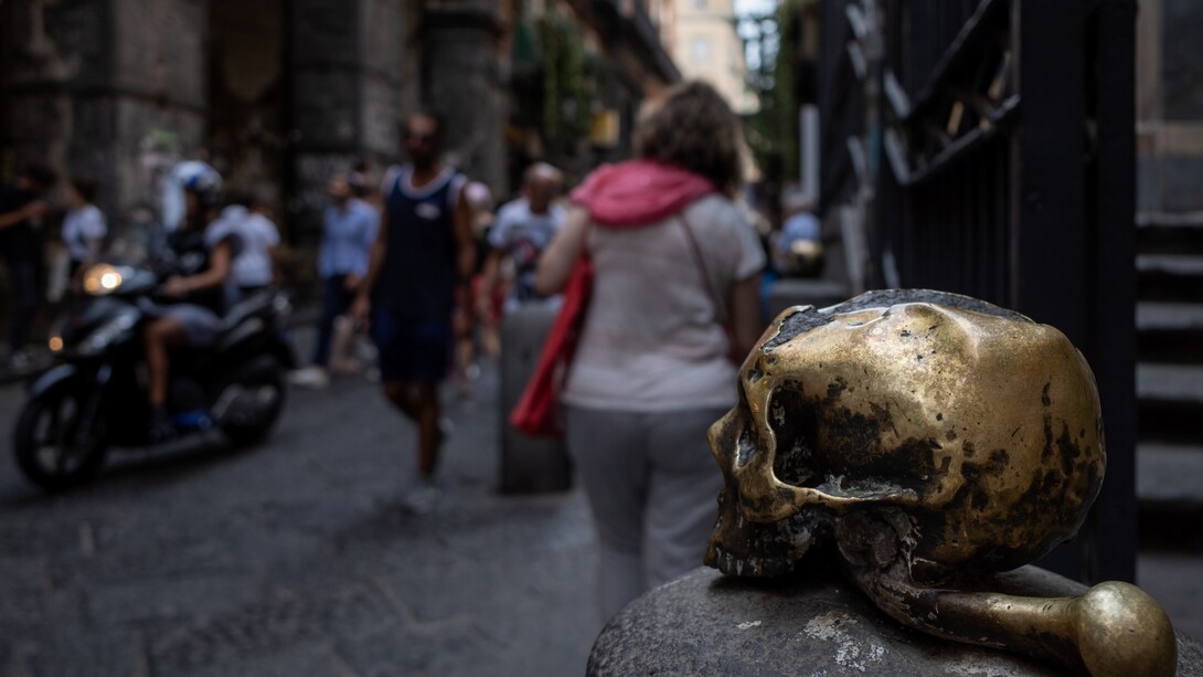 Spaccanapoli, in primo piano il teschio in bronzo posto all'ingresso della chiesa Santa Maria delle Anime del Purgatorio ad Arco, Napoli, Italia