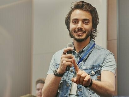 Homem dá palestra em auditório. O discurso não é simplesmente um meio de expressão, mas algo que se constrói a partir de posições de sujeito, condições sociais e instâncias que delimitam o que pode ou não ser dito