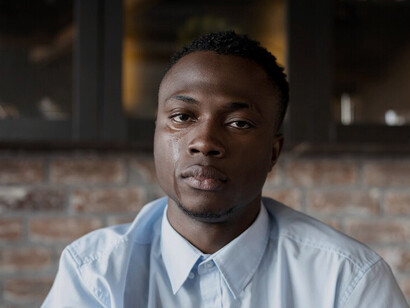 The man’s expression reflects the emotional toll of living under a patriarchal system that discourages vulnerability and emotional openness, leaving many men struggling in silence