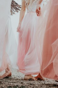 Donne che si tengono la mano in eleganti abiti color cipria 