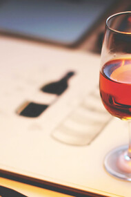 A glass of rich red wine sits elegantly on the table, adding a touch of sophistication to the scene