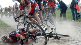 Un ciclista cae al suelo durante la disputa de la prueba París-Roubaix