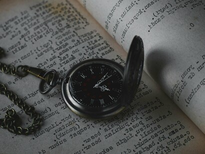 Relógio de bolso sobre livro. Embora sejam coisas diferentes, tempo e aspecto se relacionam em muitos casos. É frequente, por exemplo, o aspecto ser manifestado pelo tempo verbal. Em O pássaro saltita e Ele bebericava, o aspecto iterativo, isto é, de repetição, é dado pelos sufixos -itar e -icar, respectivamente. Em outros casos, o aspecto é dado pelo uso de um verbo auxiliar. Em As mercadorias começaram a chegar e As mercadorias acabaram de chegar, os verbos auxiliares começar e acabar exprimem que a ação é apresentada em seu início e em seu término, respectivamente