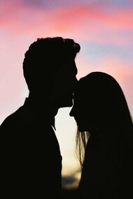 A tender silhouette of two figures in a close embrace against a vibrant sunset sky, symbolizing the profound intimacy and soul-level trust achievable when individuals navigate relationship fears through Jungian self-awareness and conscious partnership