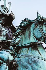 A statue of a man riding a horse, depicting a samurai in traditional Japanese armor