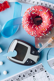 Glucometer, donut, and tape measure on blue background
