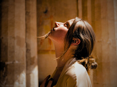Une femme en manteau beige au temple de Louxor, Louxor, Égypte