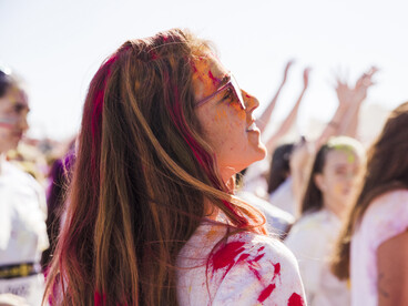 A young woman at a festival, sprayed with paint