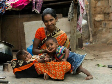 “Reducir las desigualdades es un imperativo ético. La injusticia social está acabando con la vida de muchísimas personas”. Comisión de Determinantes Sociales de la Salud de la OMS. Mujer con sus hijos en el exterior de su vivienda. Gentileza de Fundación Fontilles, foto de Jordi Pla. Barrio marginal de Bangalore

