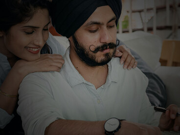 An Indian couple carefully reviewing expenses, calculating costs, and planning their household budget