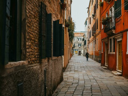 A charming Italian street with colorful façades, balconies overflowing with flowers, and narrow cobblestone alleys