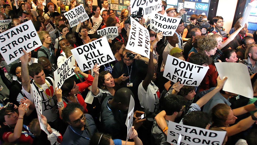 On December 9, 2011, during COP17 in Durban, hundreds protested inside the UN Climate Talks, urging nations not to sign what they called a “death sentence” for those already suffering from climate change