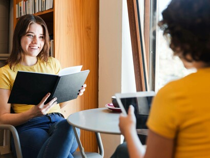 Due giovani donne al tavolino di un locale pubblico: "Questa capacità di riflettere sulla nostra conoscenza è ciò che ci rende profondamente umani"