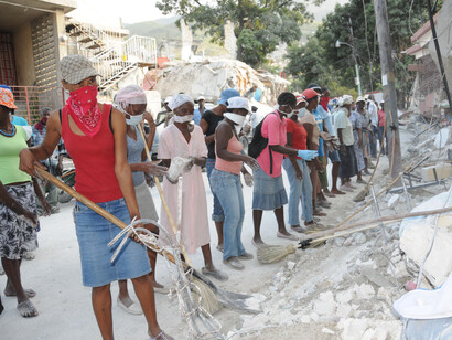 Dans le quartier de Carrefour Feuilles, des travailleurs déblayent les décombres de la rue dans le cadre du programme « argent contre travail » du PNUD, mis en place à la suite du séisme de 2010