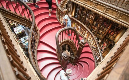 Interior da Livraria Lello no Porto, Portugal. Naturalmente, nessa imbricação entre arte, história e geografia, não nos surpreende a cartografia do nosso imaginário através da composição de rotas de viagem, itinerários cristalizando todo um imaginário específico: as de peregrinação (o Caminho de Santiago, p. ex., do séc. IX, a Jerusalém, que se simboliza e miniaturiza nos Montes Sacros), as místicas e enigmáticas (o Caminho ou a Linha Sagrada de São Miguel Arcanjo, da Irlanda a Israel, com 7 santuários a ele dedicados), as de objectos mágicos (a do Graal, de Jerusalém à Península Ibérica), as dos Contos de Fadas (com destaque para a alemã, com c. 600 Km e 60 municípios entre Hanau, onde nasceram Jacob e Wilhelm Grimm, e Bremen, do conto “Os músicos de Bremen”),  e tantas outras relacionando elementos temática ou estilisticamente (a do Românico, do Gótico, etc.) afins