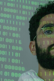 Códigos de linguagem científica são refletidos em rosto de cientista