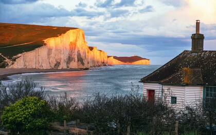 The Seven Sisters Cliffs glowing at sunset by the sea, United Kingdom