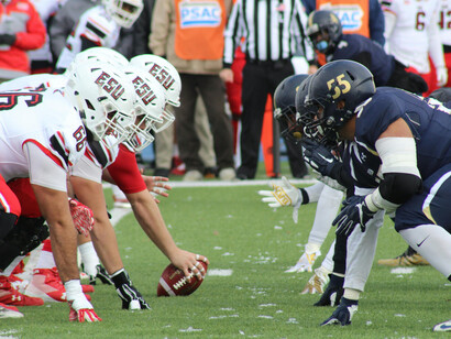 A close-up of the moment before the play, with football players focused and ready