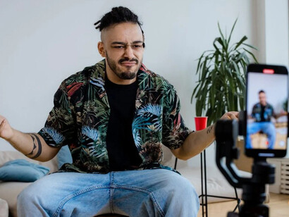 A man blogging on his smartphone, illustrating the power of digital media trends and the rise of social media influencers