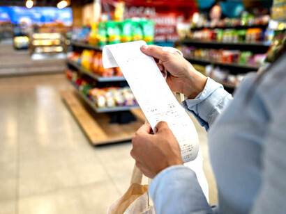 A convenience store shopper checking her receipt, capturing the impact of inflation