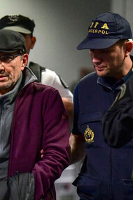 On December 16, 2019, Mario Sandoval, an ex-Argentinian police officer facing accusations of crimes against humanity from the "dirty war," is escorted by police at Ministro Pistarini International Airport in Buenos Aires after his extradition from France