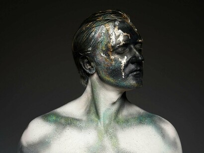 A person whose face holds multiple colours and textures, reflecting the inner contradictions that define authentic male characters