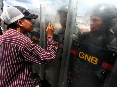 Activista de la oposición protestando frente a miembros de la Guardia Nacional de Venezuela durante una protesta en San Cristóbal, estado de Táchira, octubre de 2016