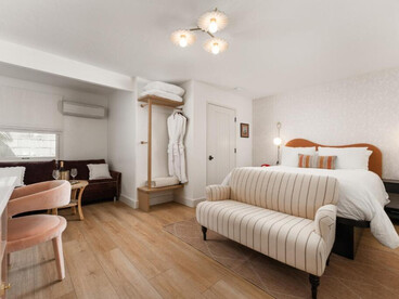 The room feels airy, calm, and inviting, with a soft neutral palette and subtle warm accents