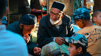 Elderly men and children sitting together, reflecting the warmth and traditions of Uzbek culture in Uzbekistan
