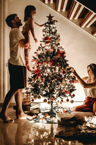 Família prepara árvore de natal e pendura decorações 