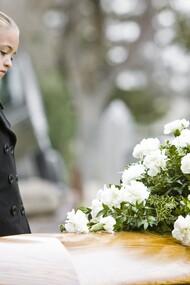 Una niña junto a un ataud