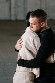 Pessoas se abraçam em referência aos efeitos terapêuticos para uma vida em sociedade