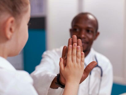 Medico che da il cinque a una bambina: “Il rispetto attivo ... non si limita a non nuocere, ma comporta un coinvolgimento positivo e consapevole verso gli altri”