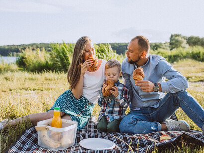 Enjoying a sunny day, a family shares a picnic and delicious pizza in the park