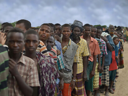 Internally displaced people affected by flooding and clan conflict wait for food assistance at an AMISOM military camp near Jowhar, Somalia, on November 12
