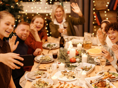 A family celebrating Christmas dinner while taking a selfie