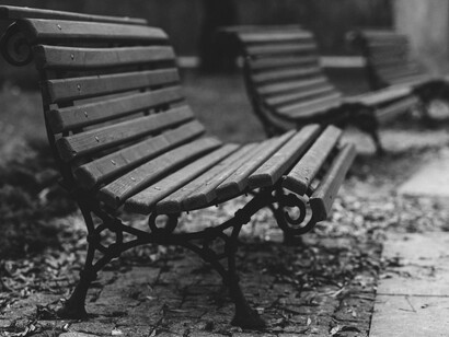 The unoccupied bench rests in stillness, its solitude amplified by the silence of the empty streets