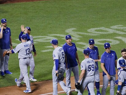 Los Angeles Dodgers players seen high-fiving after winning a baseball match in 2023, showcasing their camaraderie and team spirit