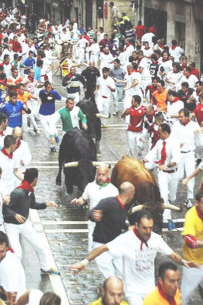 Encierro de toros de Pamplona: vestimenta típica demostrada con los atrevidos azules e incluso una camiseta con la pata de un tigre de Clemson para atraer la atención de los toros. 2014, Pamplona, Navarra, España 