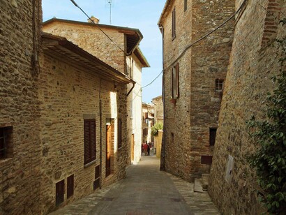 Vicolo stretto tra mura in pietra, Montone, Umbria, Italia