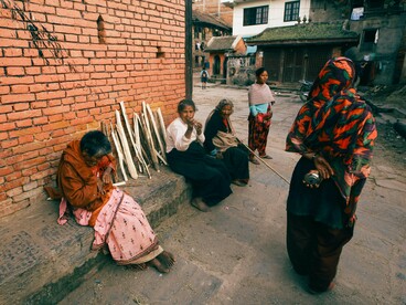 A group of homeless women gathered on a city street, symbolising the collective vulnerability created by the global housing crisis
