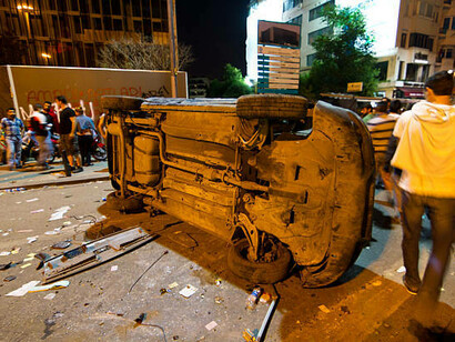 An overturned car bearing protest graffiti, a stark symbol of unrest in Türkiye, 2013