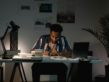 Man sitting at his desk appearing tired and overworked