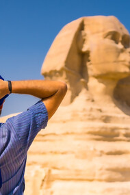 A man standing in front of the Great Sphinx of Giza, Egypt