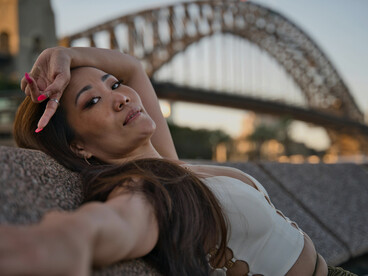 Sunset view of a woman posing by the Sydney Harbour Bridge in Sydney, Australia