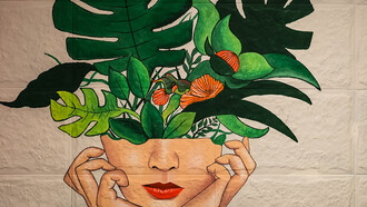 A painting of a girl with green and red flowers emerging from her head, symbolizing the concept of love as a force for personal growth and mental health