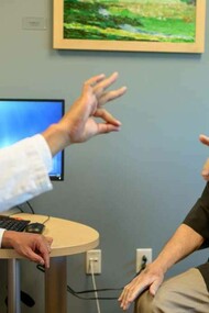 A doctor helping a patient who has Parkinson's disease